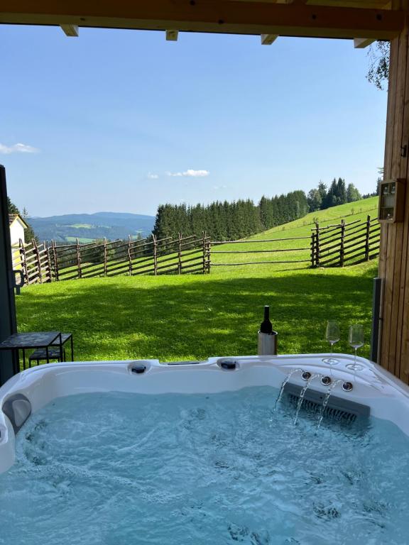 a jacuzzi tub with a view of a field at Waldheimatblick in Sankt Kathrein am Hauenstein