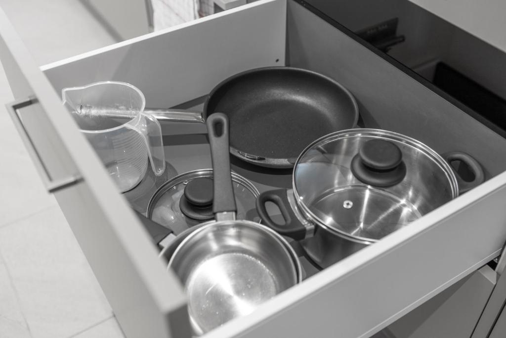 a drawer filled with pots and pans in a kitchen at STAYY Flagship Limmattal - contactless check-in in Schlieren