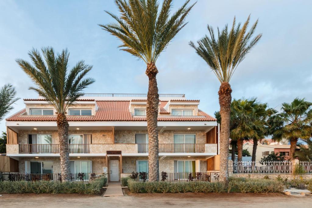 un edificio con palmeras delante en Villa ao Mar en Santa María