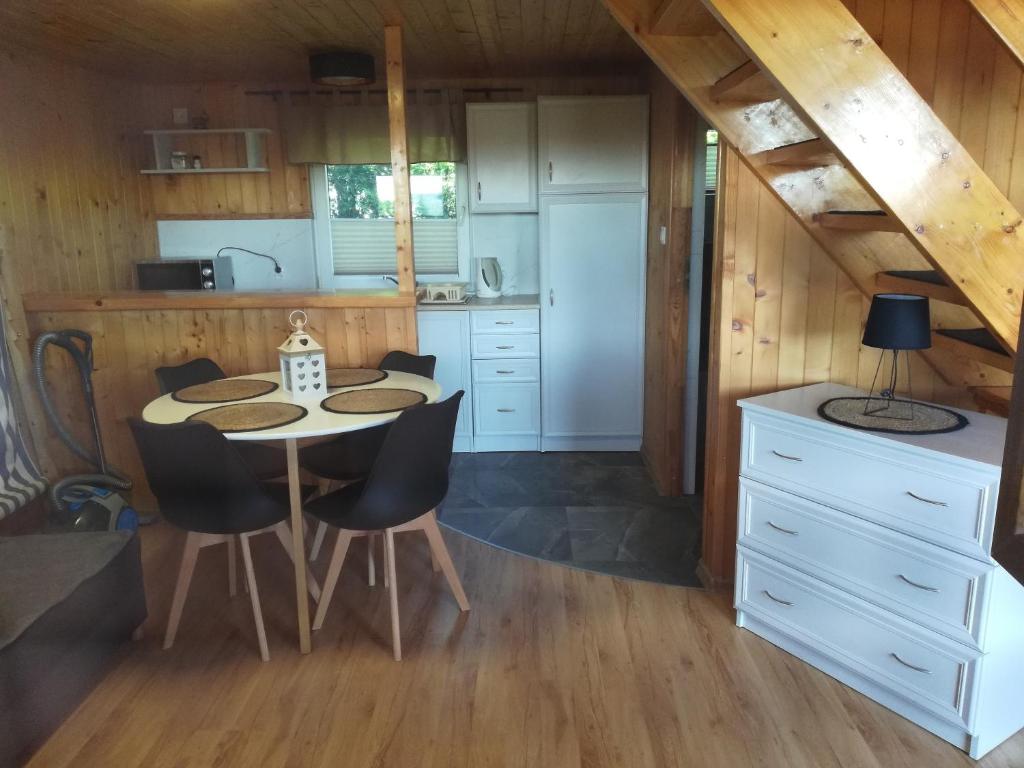 a kitchen with a table and chairs in a room at Domki Mantras in Swarzewo