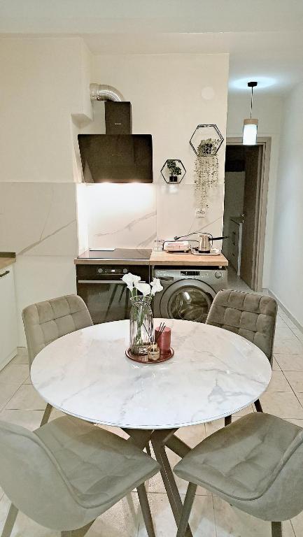 a kitchen with a white table with chairs and a table at SOLI Apartment in Neoi Epivates