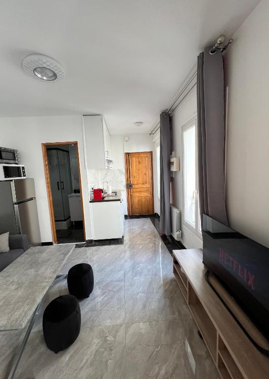 Il comprend un salon avec une télévision et une cuisine. dans l'établissement Paris 2024 Olympics 3-4 persons, à Paris