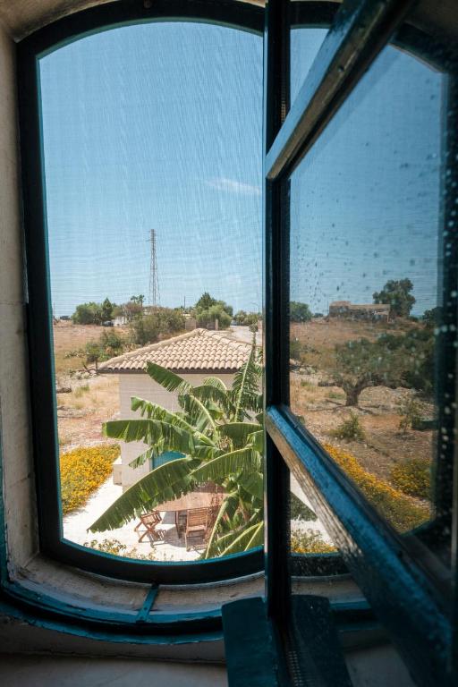 an open window with a view of a building at B&B Fermata 106 da Carolina in Siculiana Marina