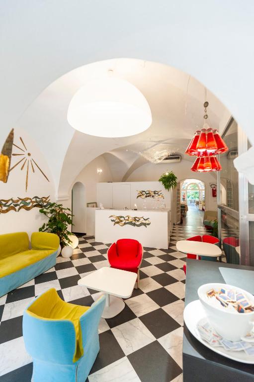 a lobby with colorful chairs and tables in a room at Hotel Melograno in Spotorno