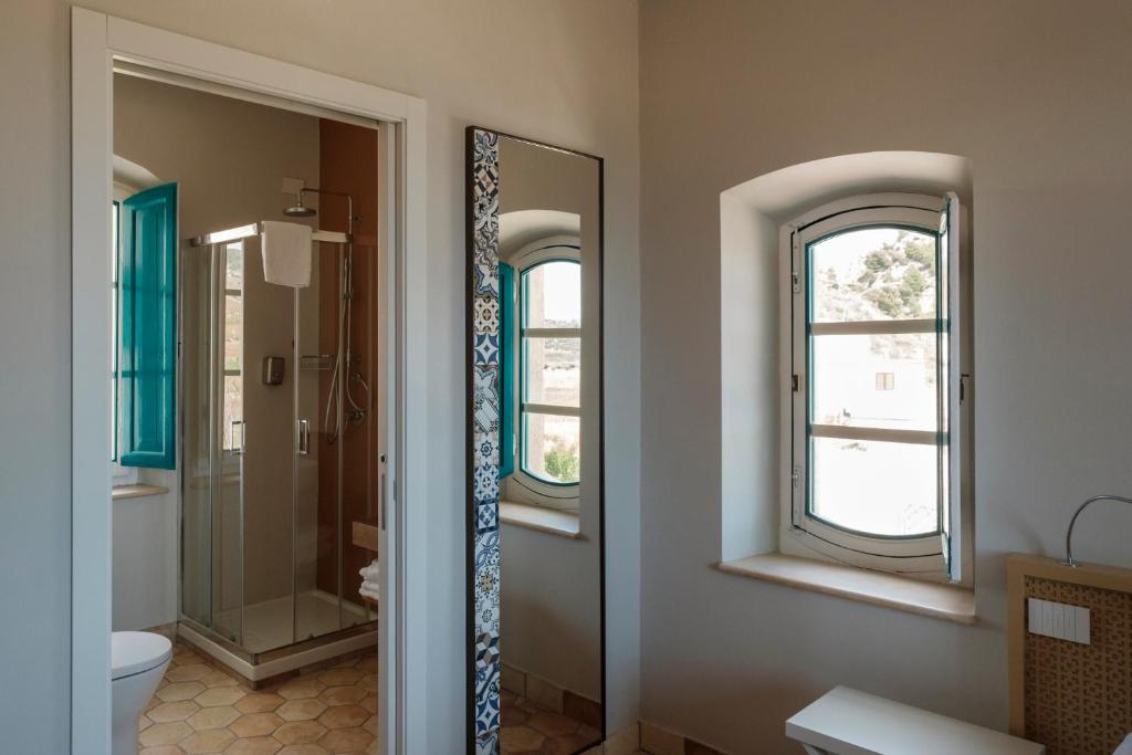 a bathroom with a shower and a toilet and two windows at B&B Fermata 106 da Carolina in Siculiana Marina