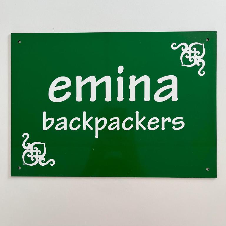 a green sign with the words eminem back packers at Otaru Eminabackpackers in Otaru