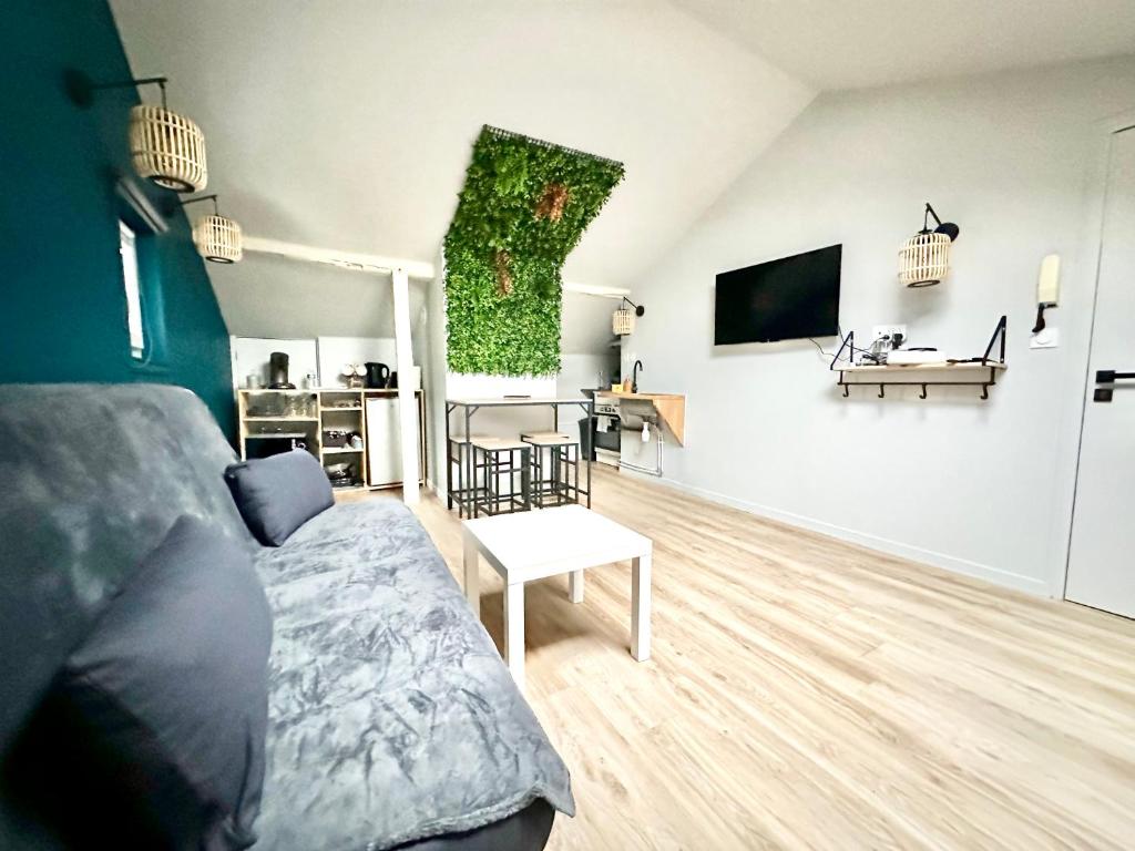 un salon avec un lit et une télévision sur un mur dans l'établissement Le Florissant, intime et raffiné, à Limoges