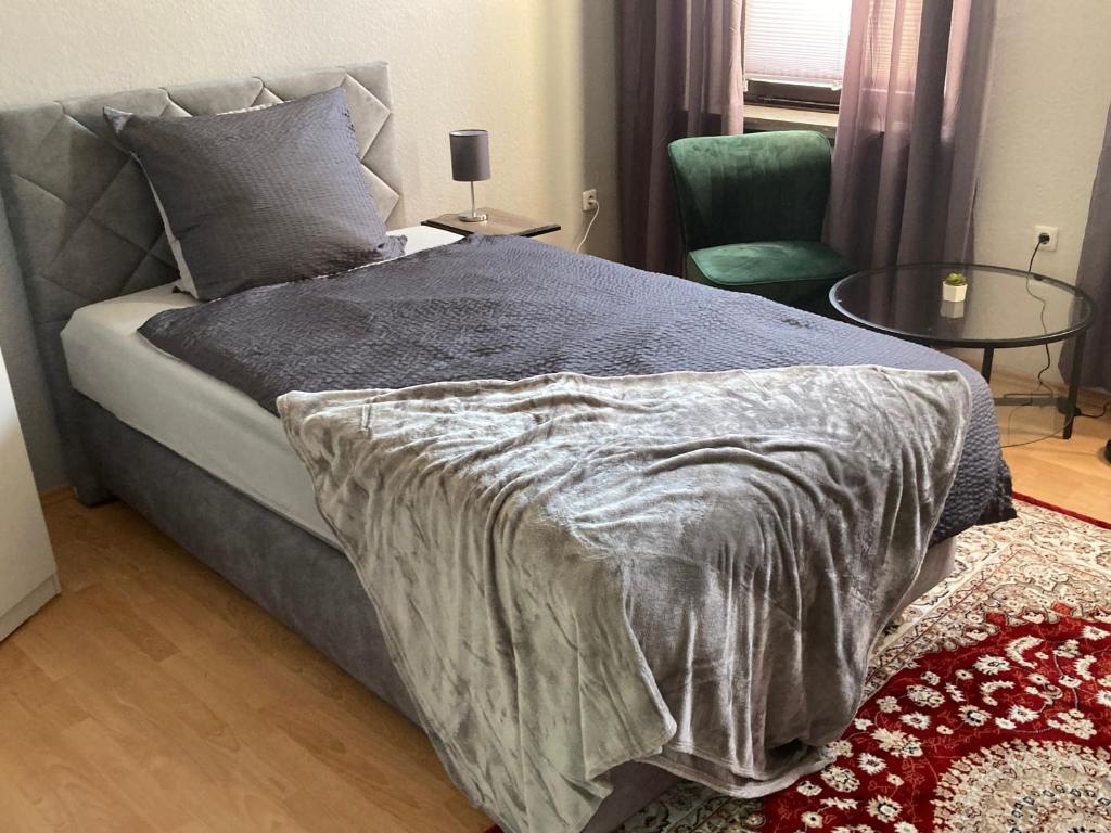 a bedroom with a bed and a chair and a table at Time-Out Westerbauer TH19 in Hagen