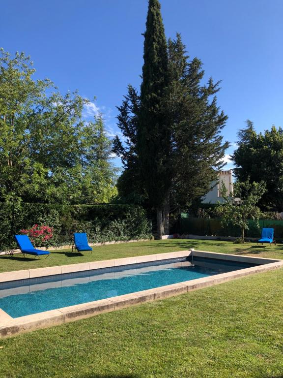 - une piscine dans une cour avec 2 chaises bleues dans l'établissement The HoPe, suite privée au sein d'une maison avec piscine, à Aix-en-Provence
