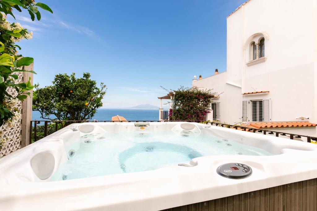 a hot tub on a balcony with the ocean in the background at Villa Elena by MyVillaCollection in Capri