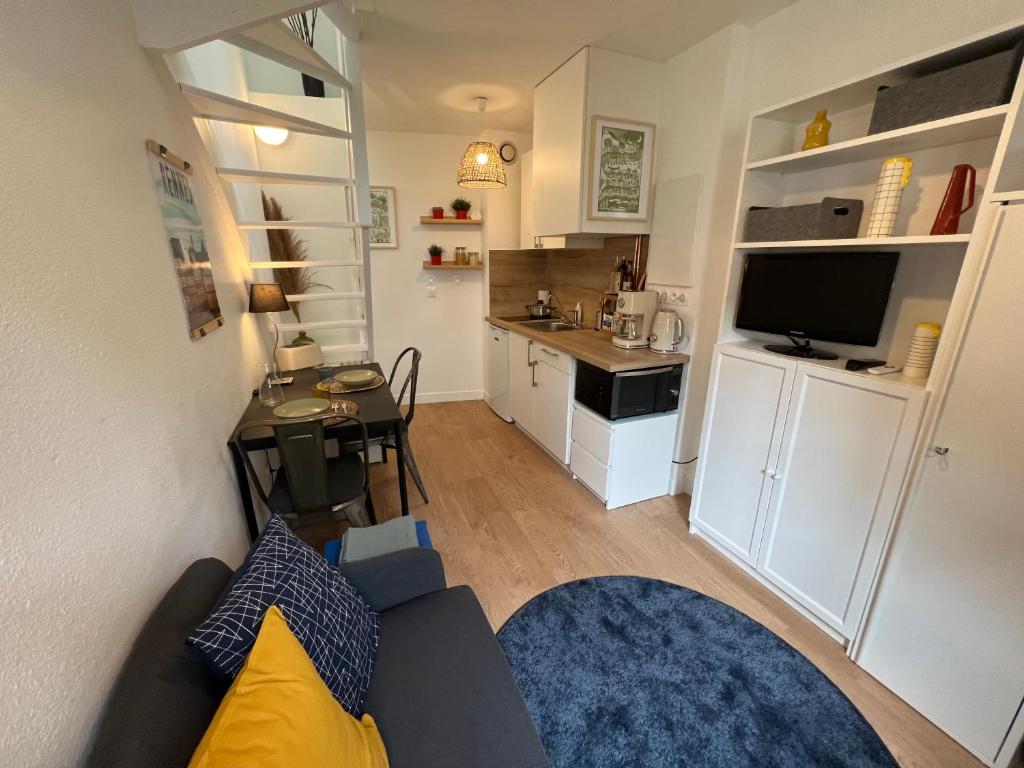 un salon avec un canapé et une cuisine dans l'établissement Duplex Cosy / Terrasse / Cour Intérieure, à Rennes