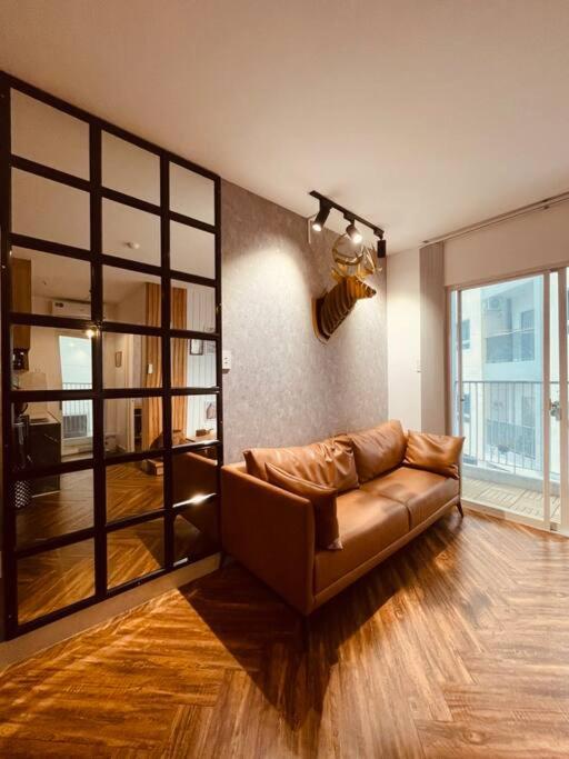 a living room with a brown leather couch in a room at Daisy Home Luxury in Ấp Mỹ Hòa