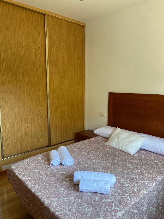 a bedroom with a bed with two towels on it at Carballeira in Moraña