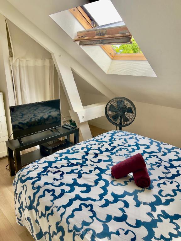 - une chambre avec un lit bleu et blanc et un ventilateur dans l'établissement Le Paris Thabor Centre-ville, à Rennes