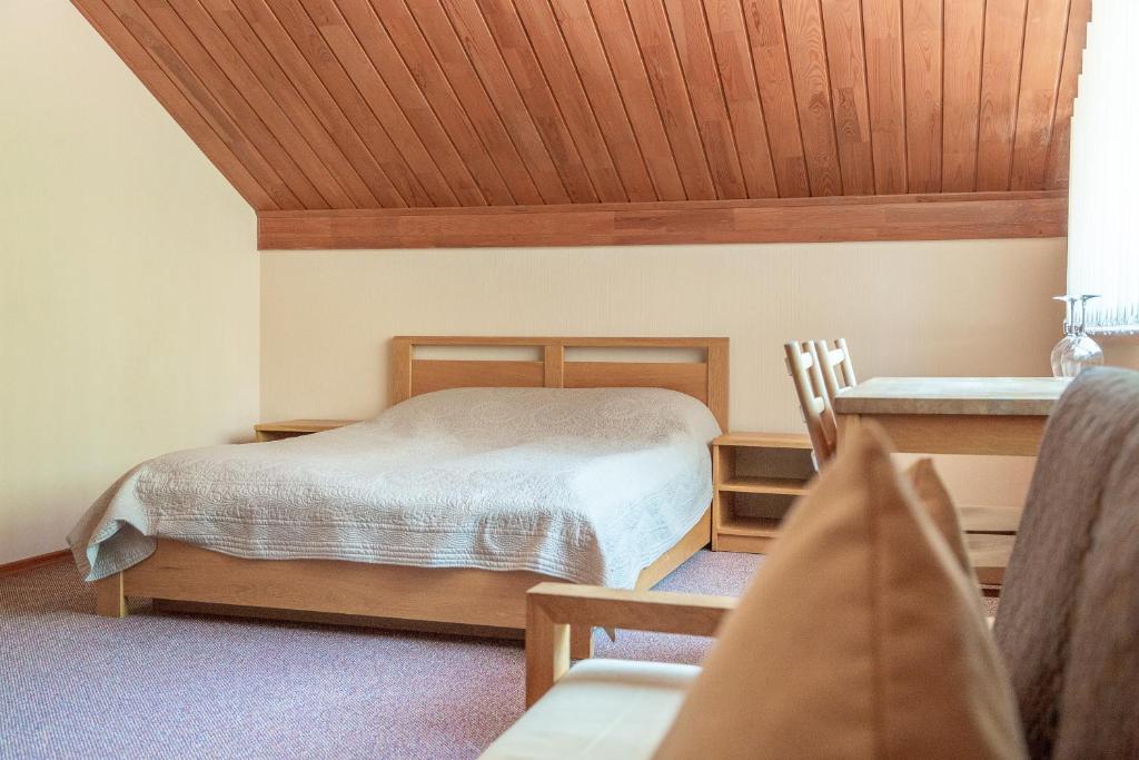 a bedroom with a bed with a wooden ceiling at Nerija in Nida