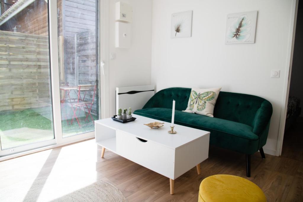 - un salon avec un canapé vert et une table basse dans l'établissement Charment T2 avec extérieur à 200m du Tram C, à Le Bouscat