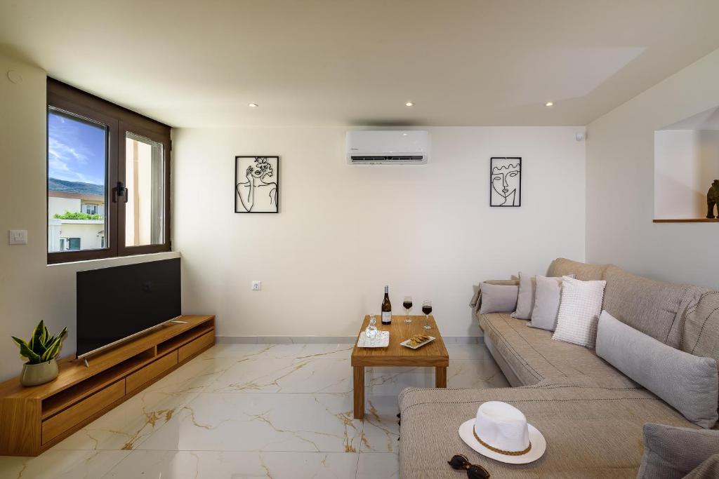 a living room with a couch and a tv at Nicolas Urban Luxury Living in Souda