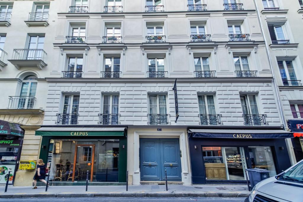a white building with blue doors on a city street at WS Opéra - Duphot in Paris