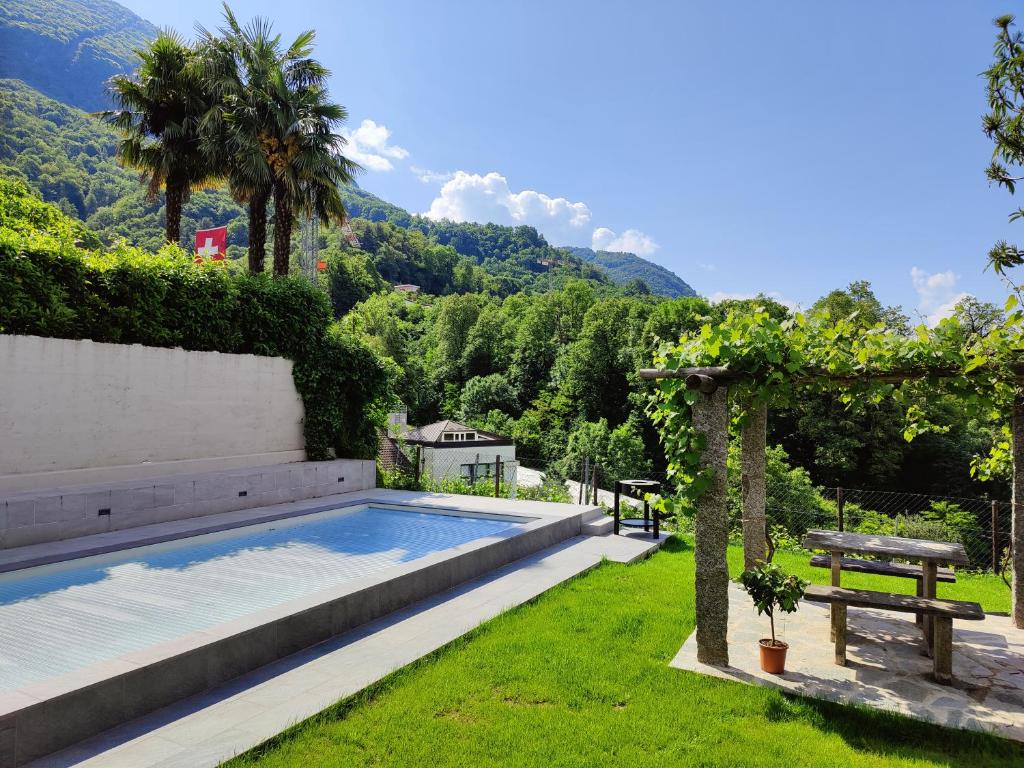 a backyard with a swimming pool and a picnic table at Casa Alla Vigna - Lugano in Pregassona
