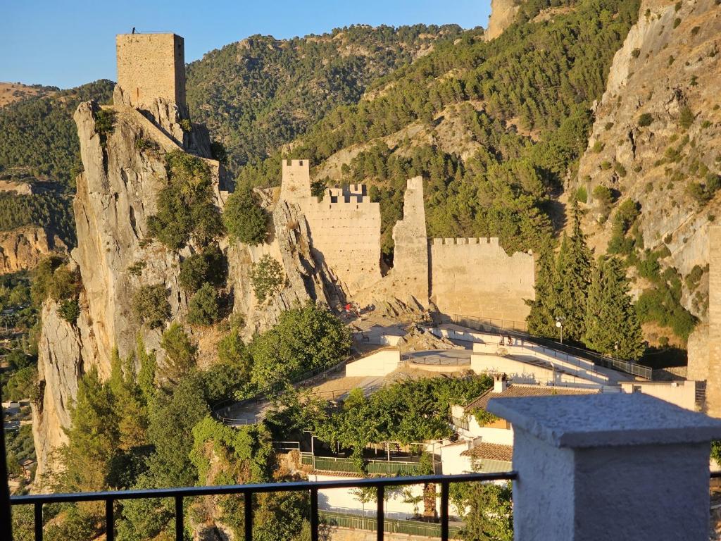 a castle on the side of a mountain at La Mocha Casa Rural - La Casa de María in La Iruela
