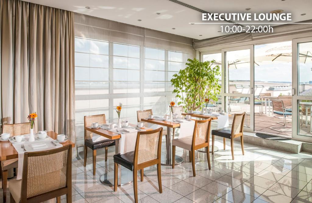 a dining room with tables and chairs and a large window at Don Giovanni Hotel Prague - Great Hotels of The World in Prague