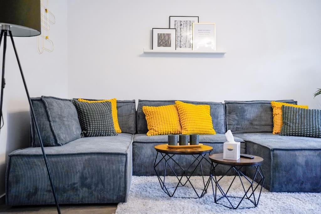 パーダーボルンにあるYellow Stationのリビングルーム(黄色の枕とグレーのソファ付)