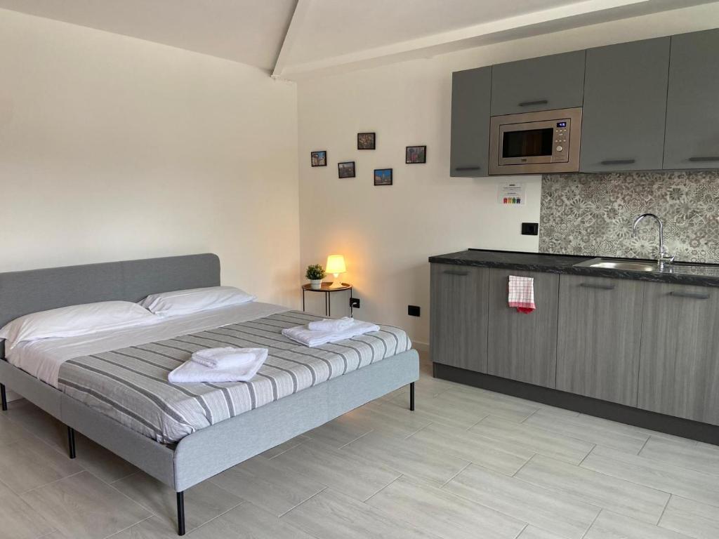 ein Schlafzimmer mit Bett und eine Küche mit Spüle in der Unterkunft Corridoni33 - Immobili e Soluzioni Rent in Bergamo