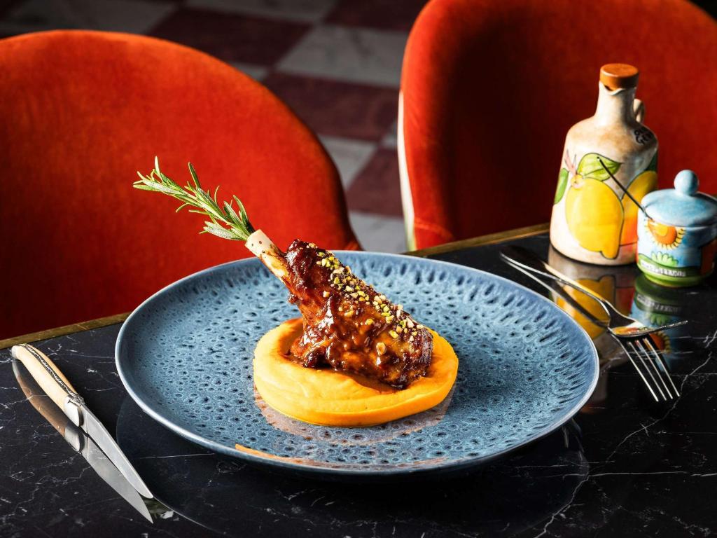 a blue plate with a piece of food on a table at Sofitel Luxembourg Europe in Luxembourg