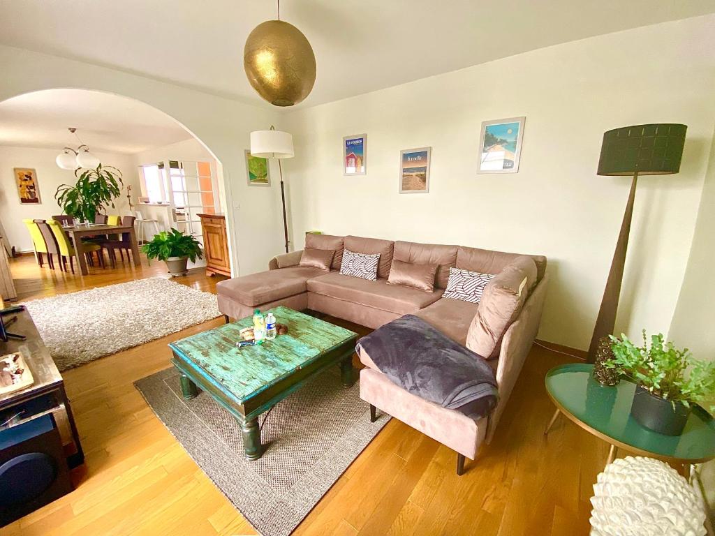 un salon avec un canapé et une table dans l'établissement Le Panoramique, splendide avec vue sur la Vienne, à Limoges