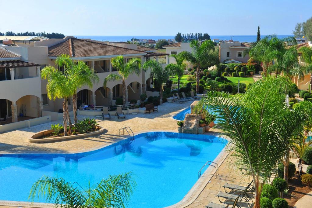 a beach with a pool and a patio area at Aphrodite Sands Resort in Mandria