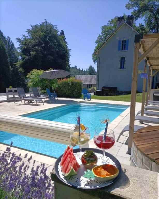 une assiette de nourriture sur une table à côté d'une piscine dans l'établissement Le Parc des 4 Saisons, à Corrèze