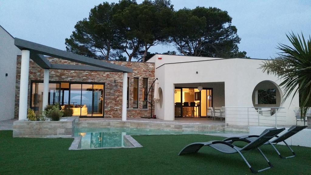 une maison avec une piscine et une chaise dans la cour dans l'établissement Villa des Anges, à Draguignan