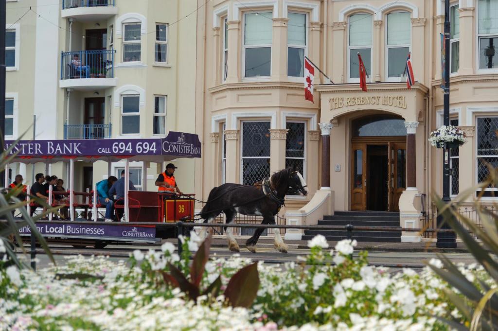 Koń biegnie przed budynkiem w obiekcie Regency Hotel w mieście Douglas