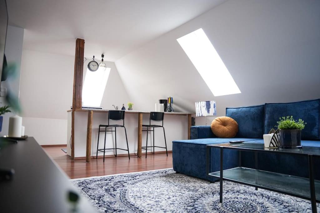 a living room with a blue couch and a table at Blue Skyline in Paderborn