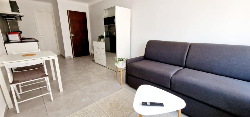 un salon avec un canapé bleu et une cuisine dans l'établissement 3 Le Saint Joseph studio in city center of Antibes with AC, à Antibes