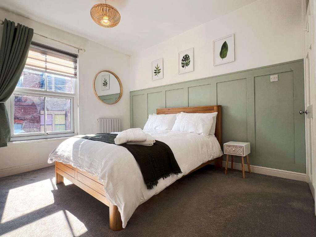 Un dormitorio con una cama grande con cabecero verde. en Your Property Box Short Stays - Severn Street, en Worcester