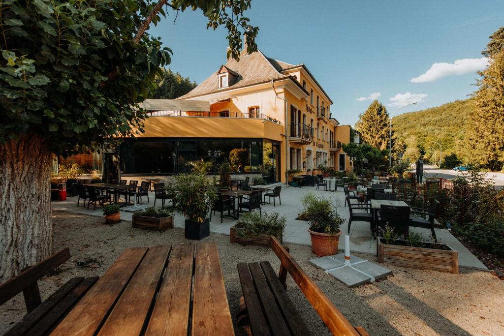 a group of wooden benches in front of a restaurant at Hotel Restaurant Le Cigalon in Waldbillig