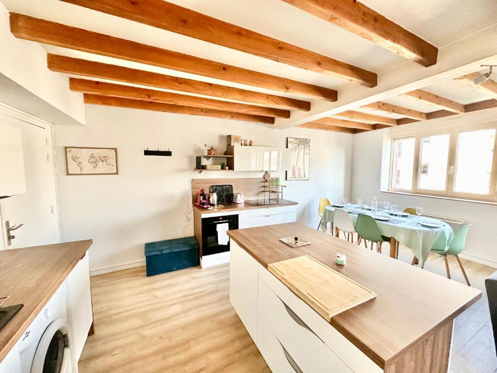 Il comprend une cuisine et une salle à manger avec des plafonds en bois. dans l'établissement L'Urban Spot, calme et lumineux, à Limoges