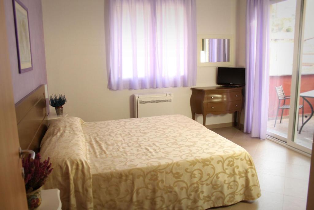 a bedroom with a bed and a desk and a window at Residence San Nicola in Alassio