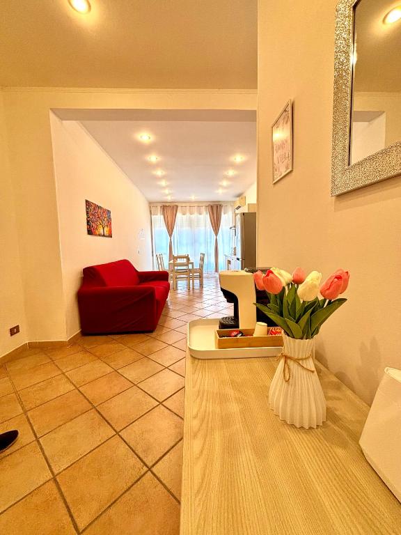 a living room with a red couch and a vase of flowers at La Dolce Vita in Bracciano