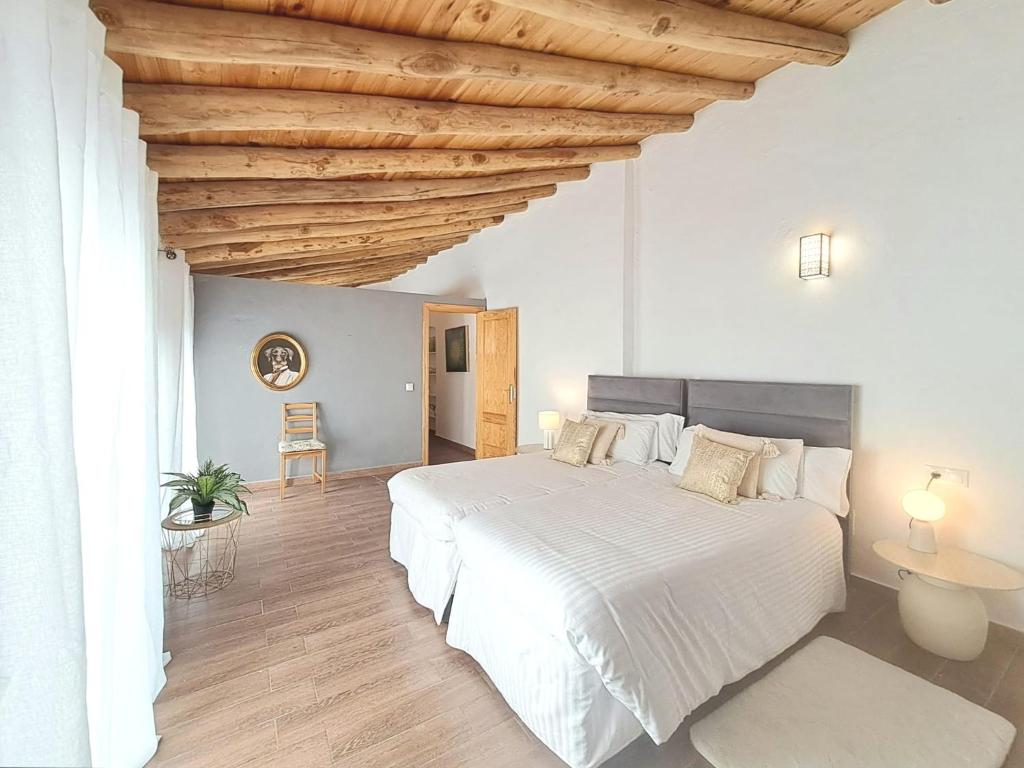 a bedroom with a white bed and a wooden ceiling at Noctua Estepona Old Town 025 in Estepona