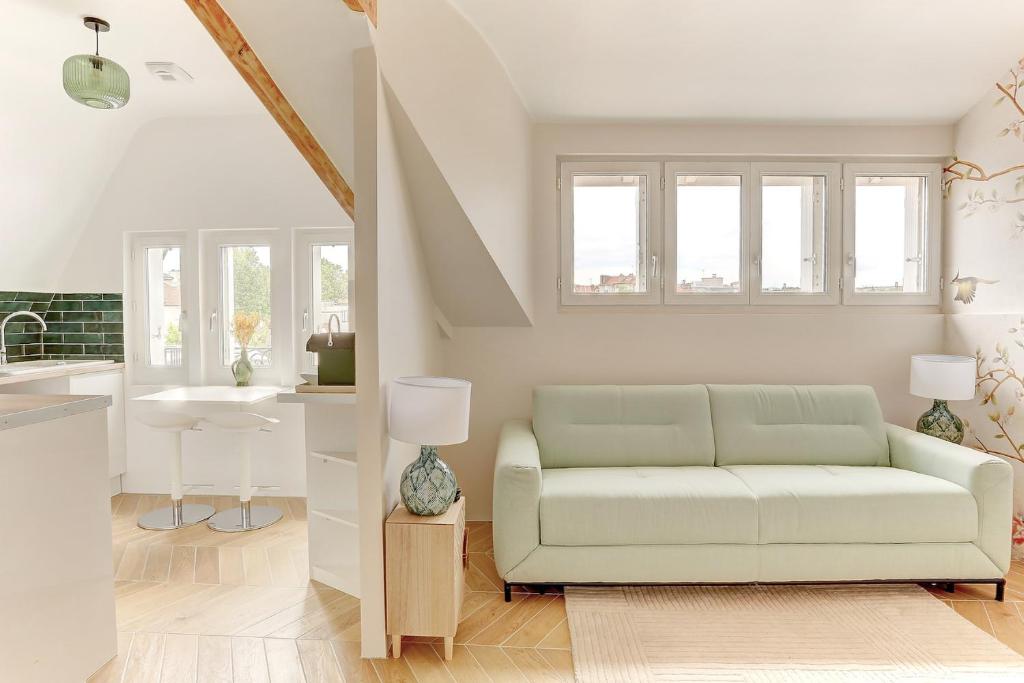 een woonkamer met een bank en een wastafel bij Le Gresset - Vanves in Vanves