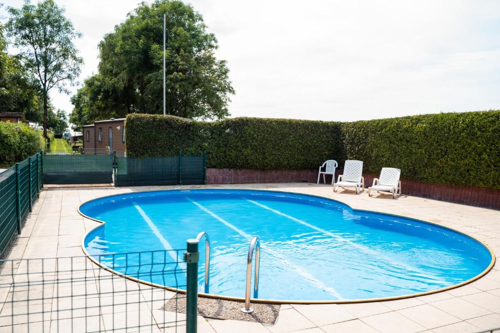 una grande piscina blu con due sedie a sdraio di Camping Um Bierg a Houschthauser