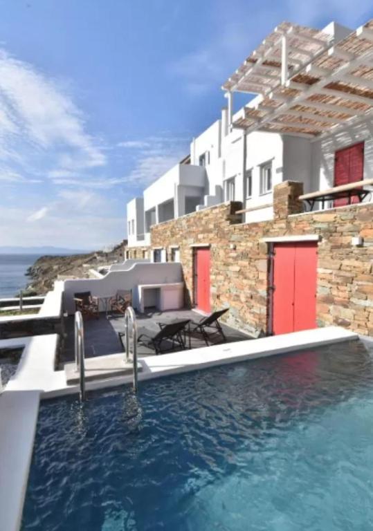 a swimming pool in front of a house at Tinos Portraits Ballos in Agios Romanos