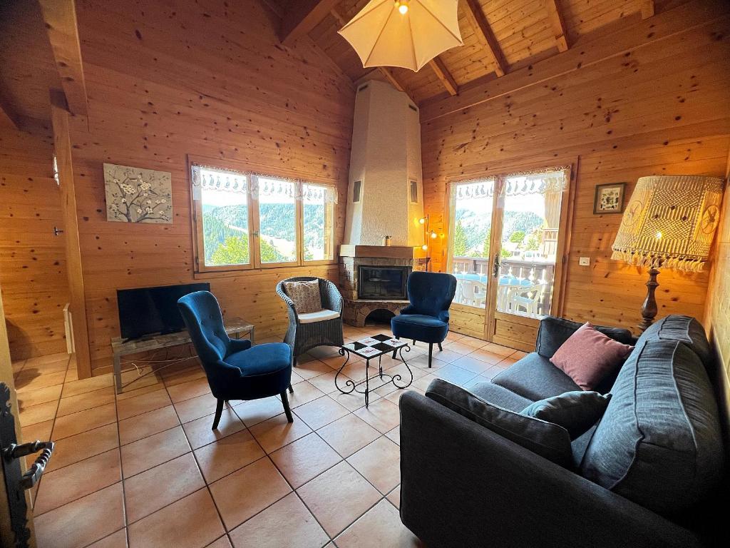 un salon avec un canapé et des chaises dans l'établissement Murgiers B1 - Chalet mitoyen, à La Clusaz