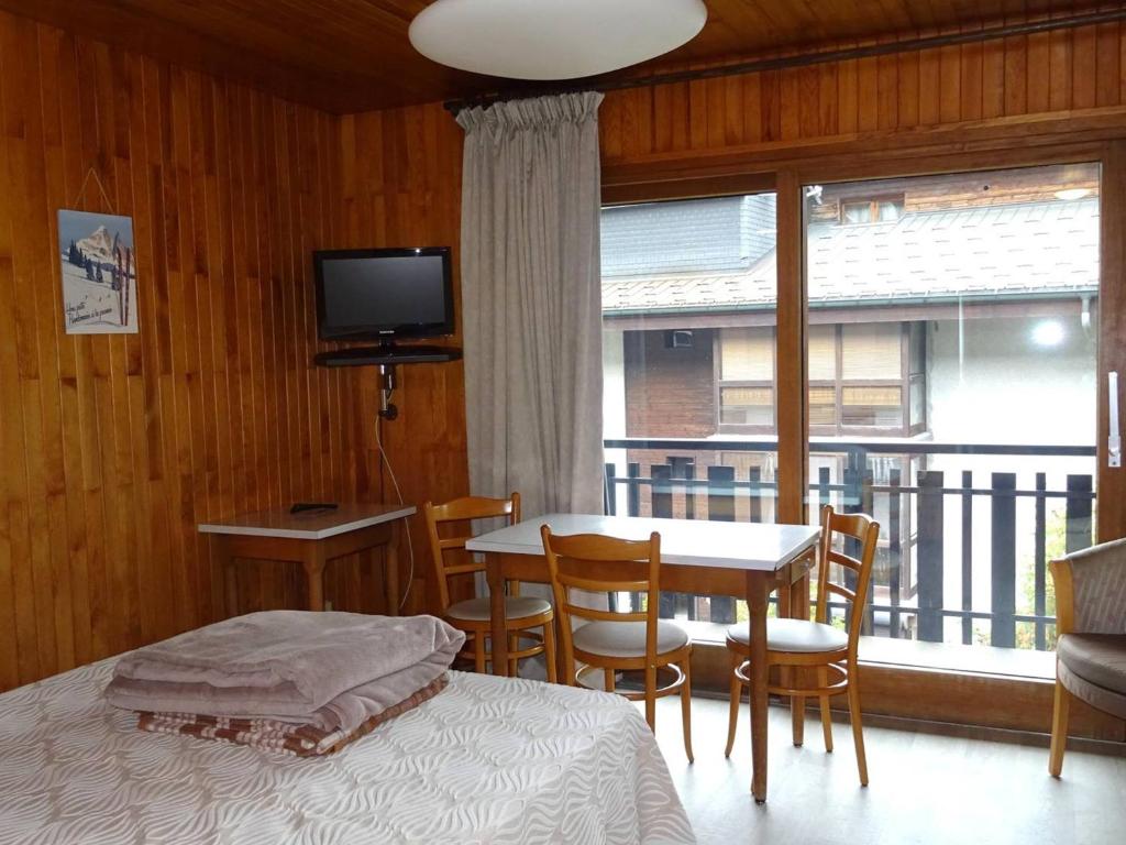 une chambre avec un lit, une table et une fenêtre dans l'établissement Studio au cœur des Gets - 2 Pers - WIFI, Draps et Serviettes Inclus, Près des Commerces - FR-1-802-43, aux Gets