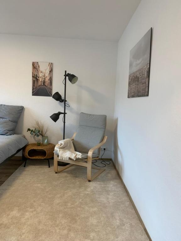 a living room with a chair and a couch at HMS16 I 1-Zimmer Apartment mit Balkon I Daimler Nähe I S-Bahn & City - Sindelfingen in Sindelfingen