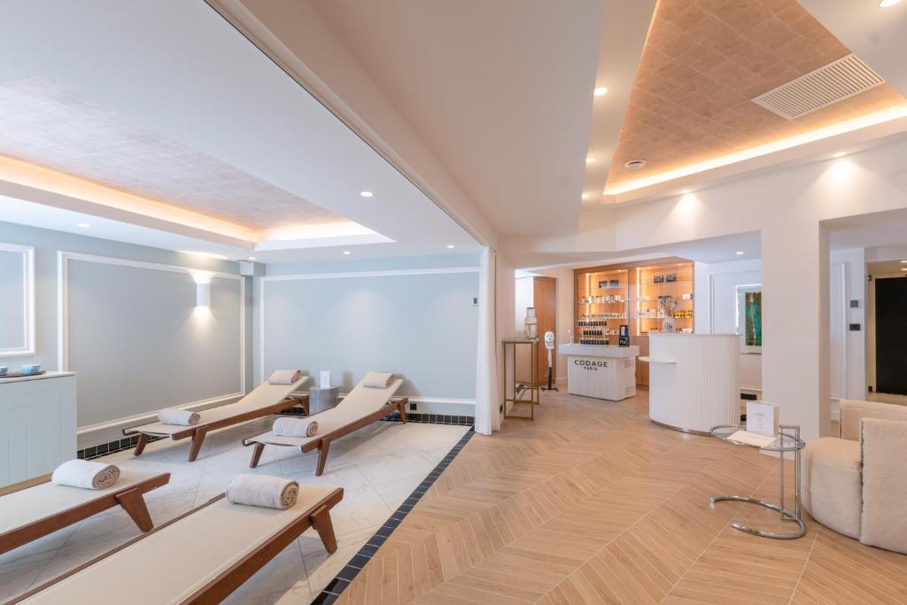 a waiting room with tables and chairs in a building at The 1932 Hotel & Spa Cap d'Antibes - MGallery Collection in Juan-les-Pins