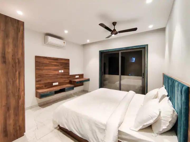 a bedroom with a white bed and a ceiling fan at FE 486 Villa in Kolkata