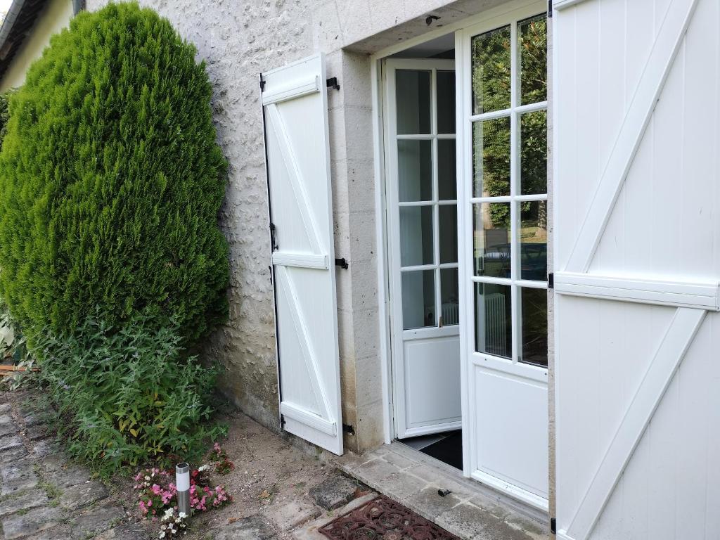 an open door to a house with a bush at Les Mulotières in Olivet
